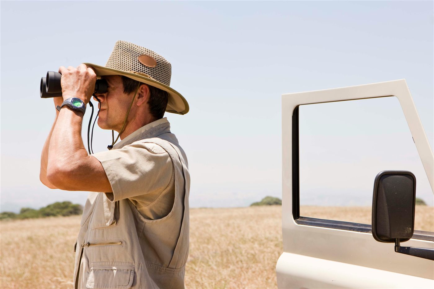 Traveller searching the Hoedspruit bushveld with binoculars